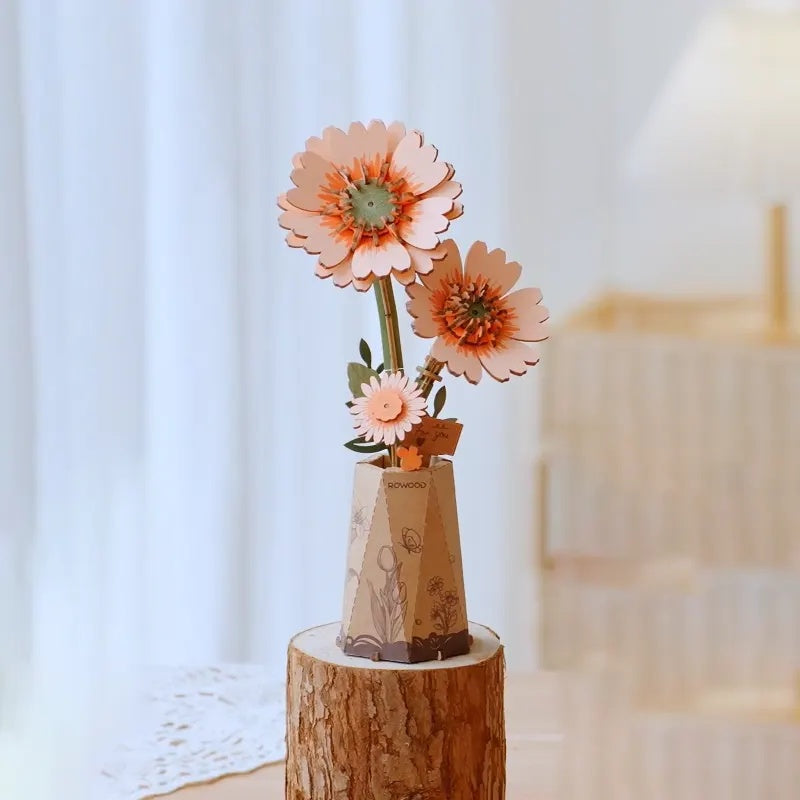 Rowood Light Orange Gerbera Daisy TW111 wooden flower puzzle displayed as home decor on a wooden stand near a bright window