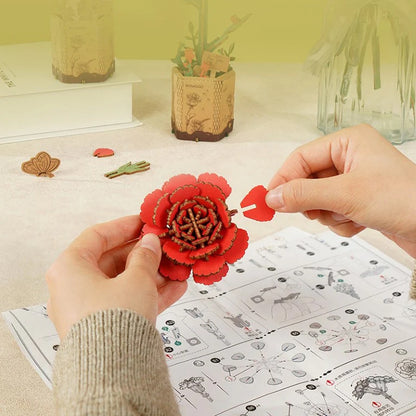 Hands assembling the red carnation petals for the Rowood TW052 DIY wooden flower craft kit.
