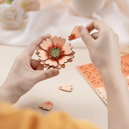 Rowood Light Orange Gerbera Daisy TW111 close-up assembly detail showing layered wooden flower petals being assembled by hand