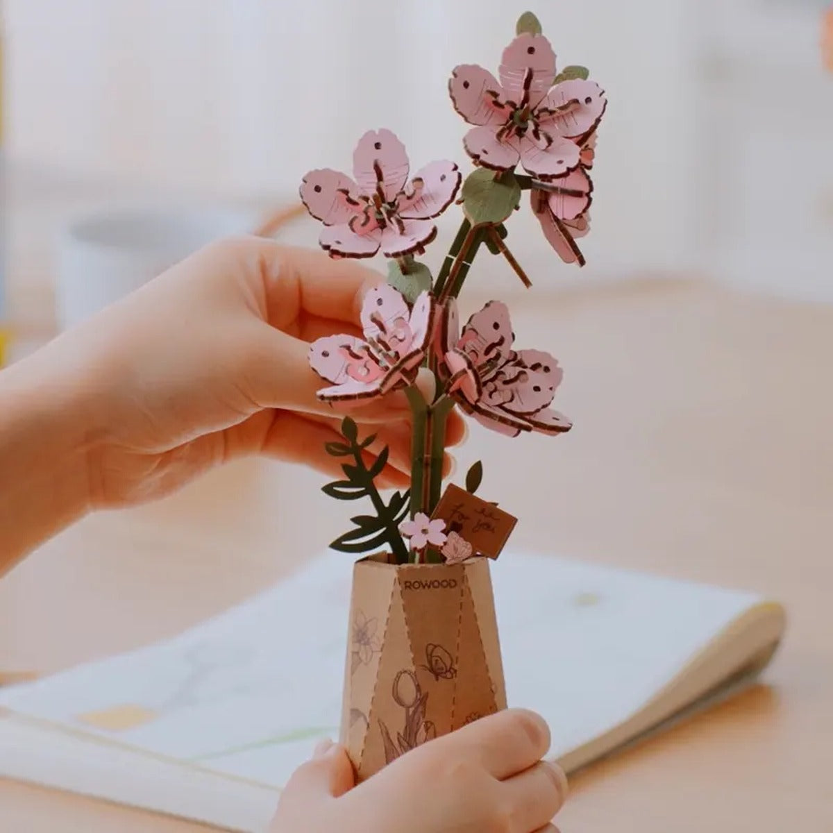 Rowood Sakura TW101 wooden cherry blossom craft held by hand during flower arrangement and display.