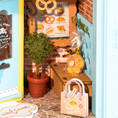 Close-up of Rolife Fluffy Cat Bakery DP001 miniature bakery details with plant, bread bag and doorway
