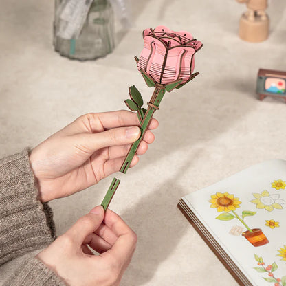 Hands assembling the pink rose stem for the Rowood Wooden Flower Bouquet TW01H DIY wooden flower bouquet kit.