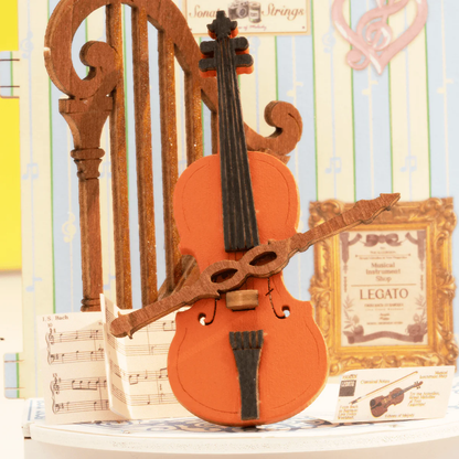 Detail view of curved window, cello and harp inside Rolife Melody Instrument Shop DS047