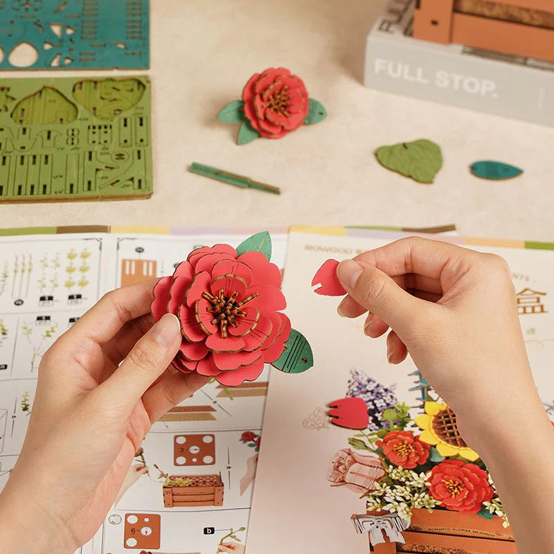 Rowood Wooden Bloom Box TW02H close-up assembly image showing the layered red camellia flower and instruction sheet