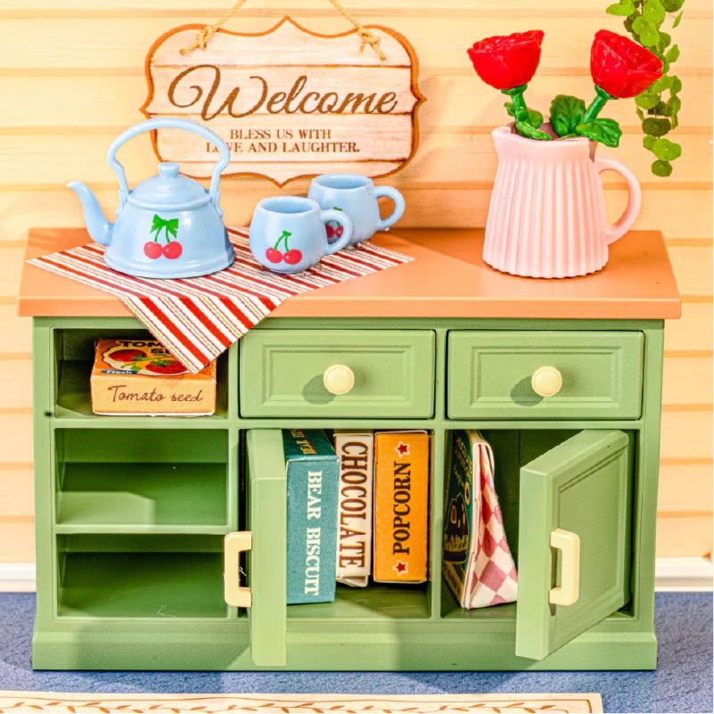 Close-up of the Sunshine Sip Porch DWS07B green cabinet, cherry tea set, flowers and storage details.
